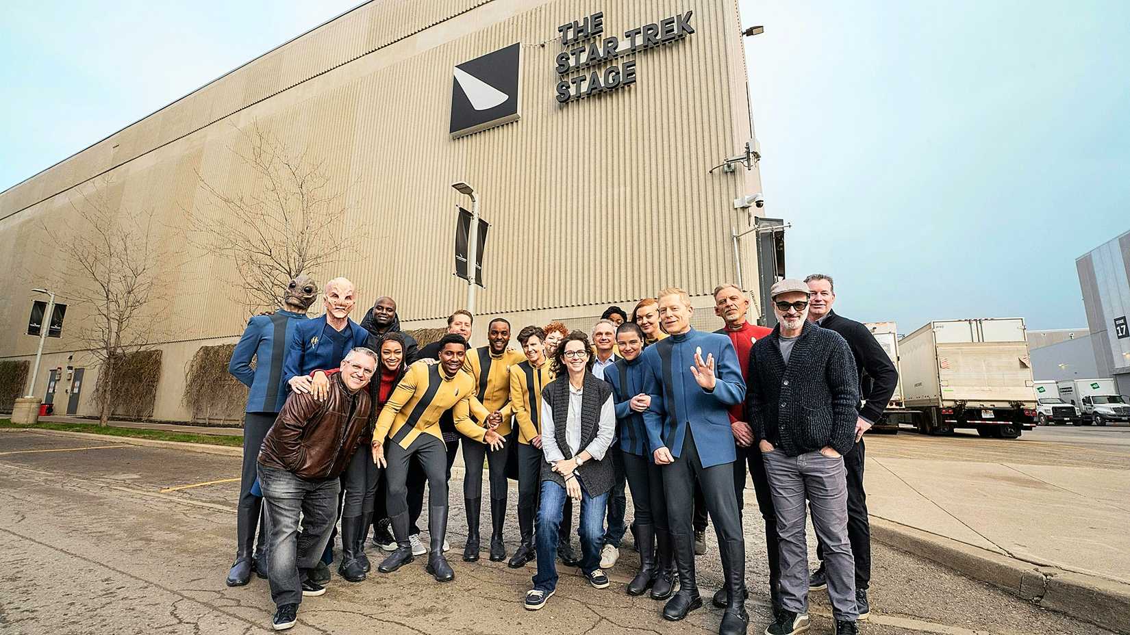 The cast of Star Trek Discovery Season 5 and Alex Kurtzman standing in front of the Toronto Star Trek stage