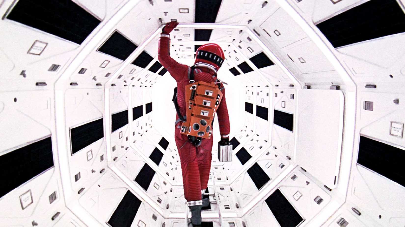 An astronaut in a red suit explores a spaceship in 2001 A Space Odyssey