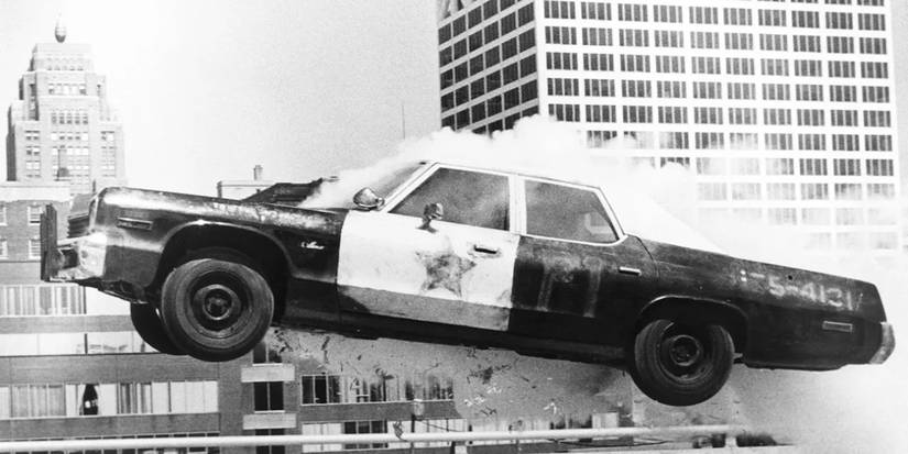 Police car jumps over obstacle as smoke billows from engine