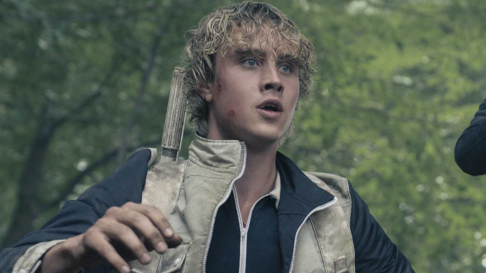 Joseph Zada as Haymith in Hunger Games Sunrise on the Reaping standing in the woods
