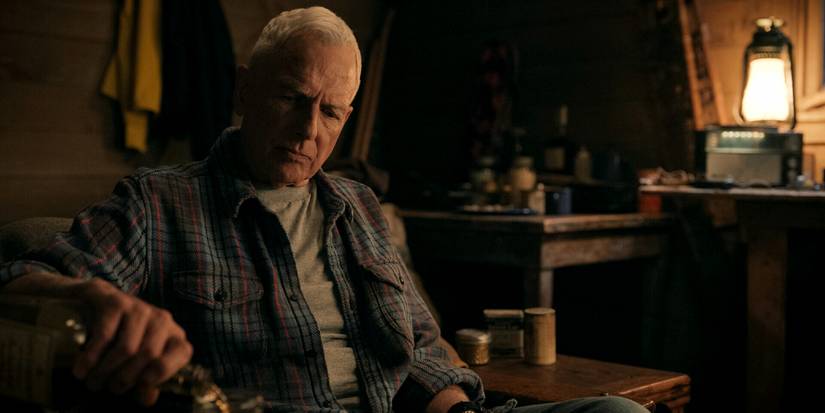 Leroy Jethro Gibbs sits at a table, pouring a drink in NCIS: Origins