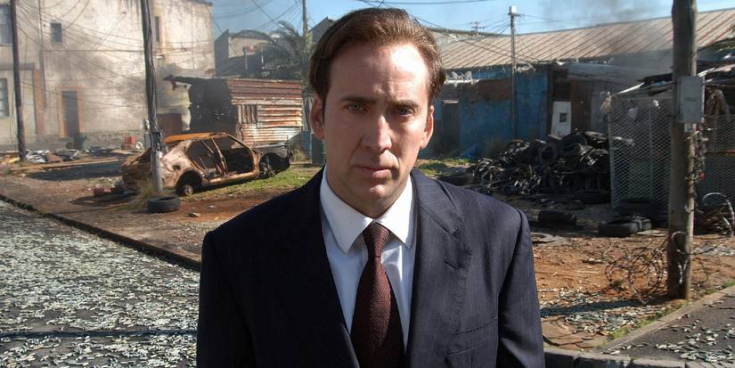 Nicolas Cage stands in front of a destroyed area in Lord of War