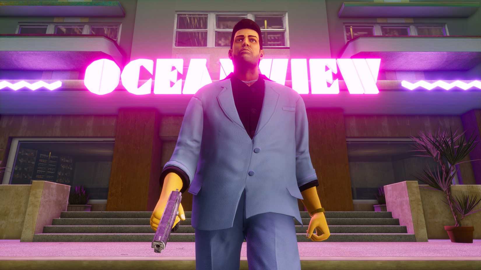 Tommy in GTA Vice City standing in front of the Oceanview building with the neon Oceanview sign lighting up the building