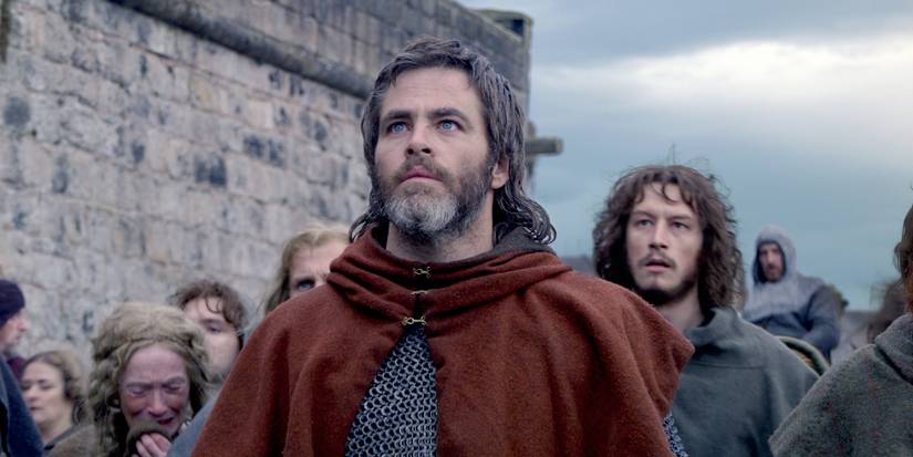 Robert Bruce (Chris Pine) looks up in shock as Earl of Carrick (Lorne MacFadyen) stand behind him in Outlaw King