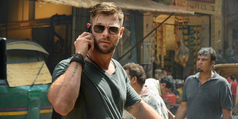 Tyler Rake (Chris Hemsworth) walking down the street while talking on the phone in Extraction