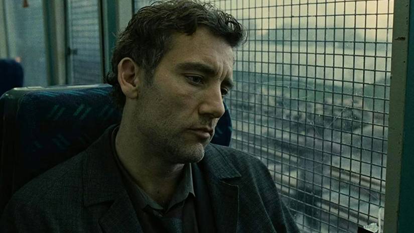 Theo Faron sits on a train as refugees can be seen through the window