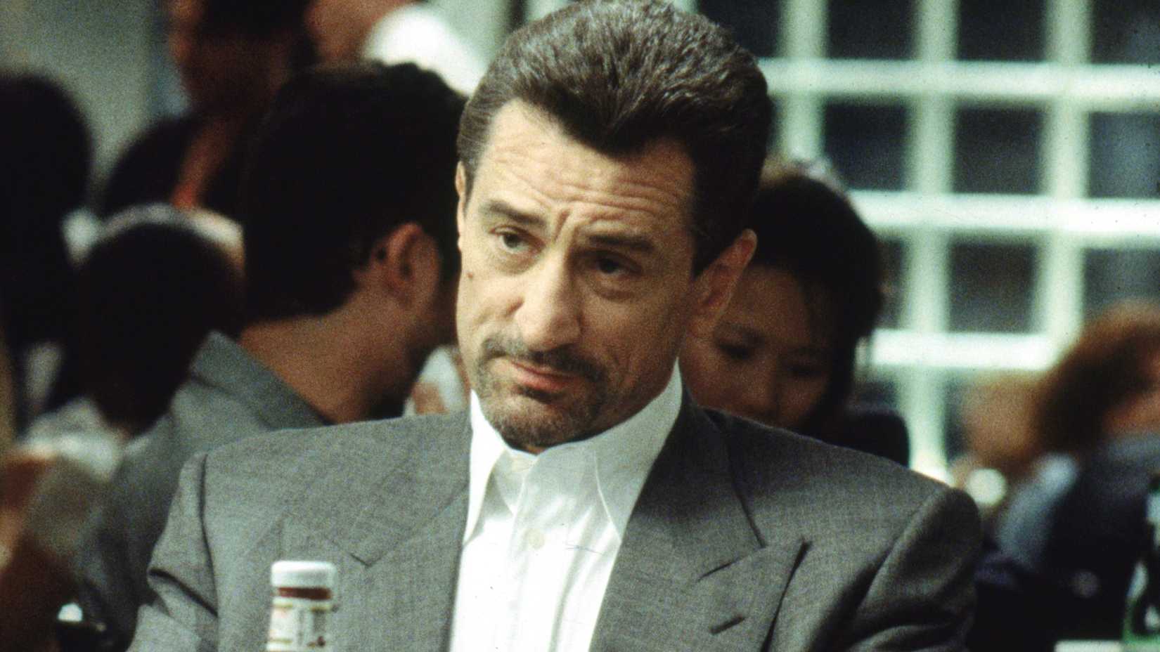 Robert de Niro sits at a dinner table across from Al Pacino in Michael Mann's Heat