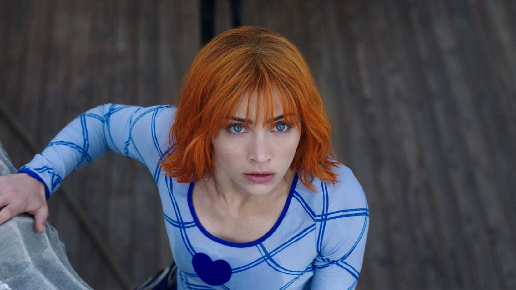 Emily Rudd as Nami wearing a blue top on the Straw Hat ship in Netflix's One Piece Live Action