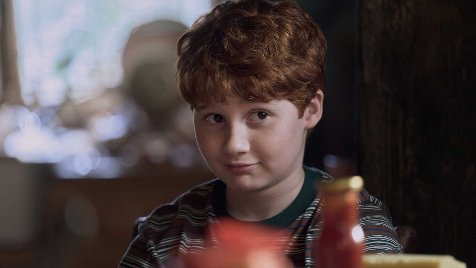 Ron smiles at the dining table in HBO's Harry Potter