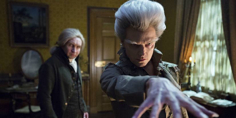 The Gentleman (Marc Warren) holds his hand in front of him while Mr Norrell (Eddie Marsan) stands behind him in Jonathan Strange & Mr Norrell