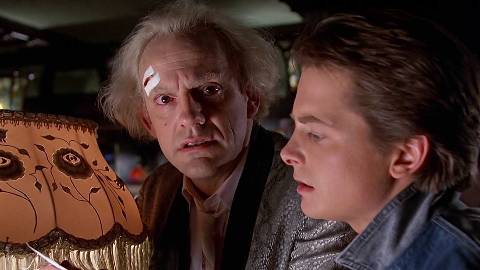 Christopher Lloyd nei panni di Doc Brown che scherza con Marty in Ritorno al futuro, in un salotto