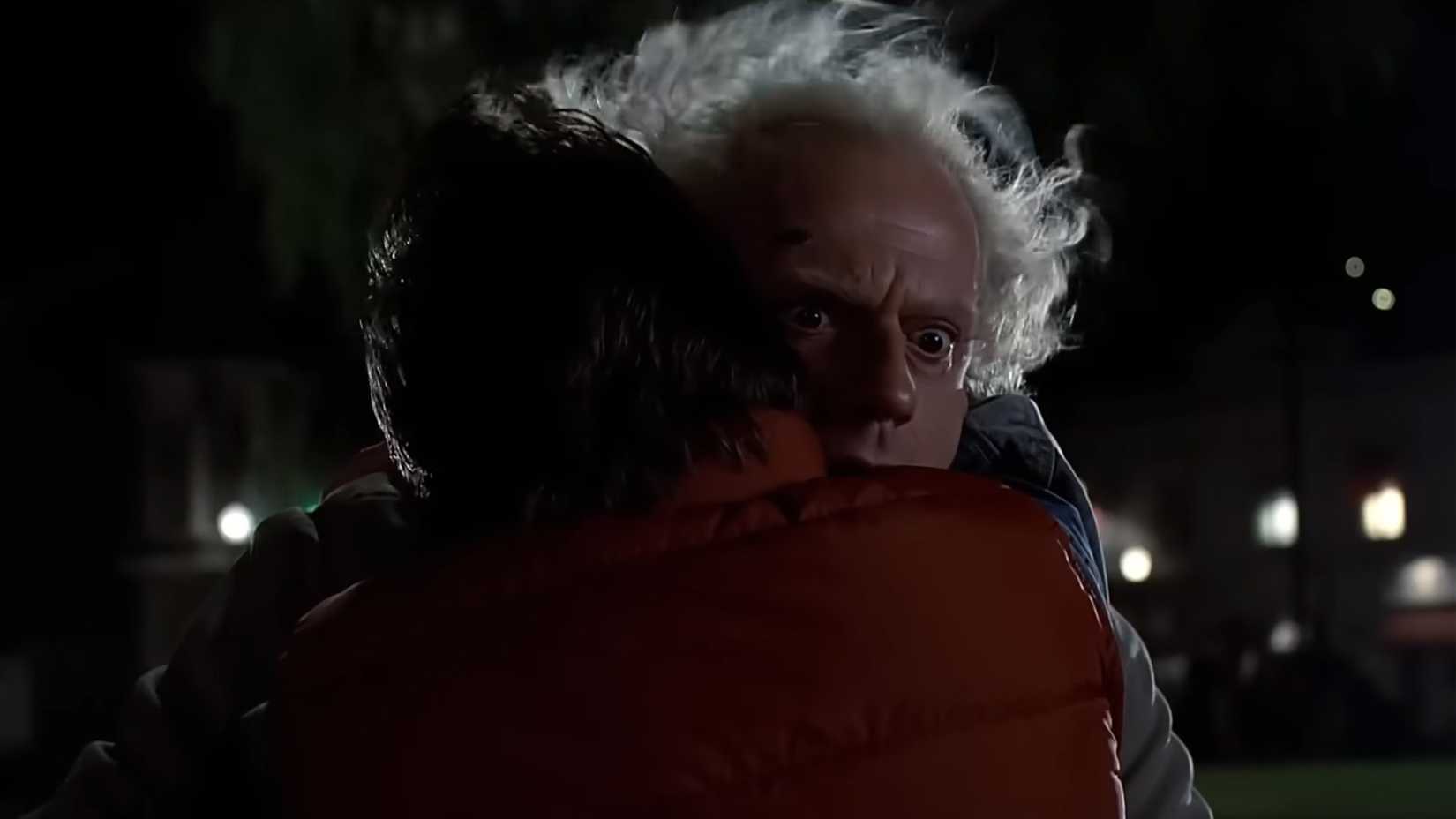 Christopher Lloyd nei panni di Doc Brown, tenuto in braccio da Marty in Ritorno al futuro