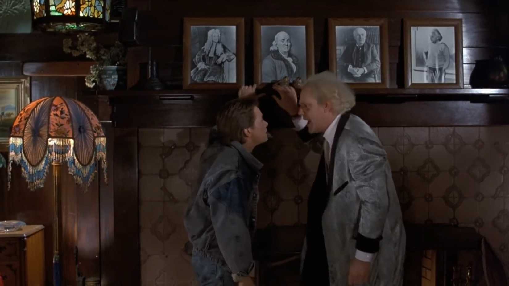 Christopher Lloyd nei panni di Doc Brown che discute con Marty in un salotto in Ritorno al futuro