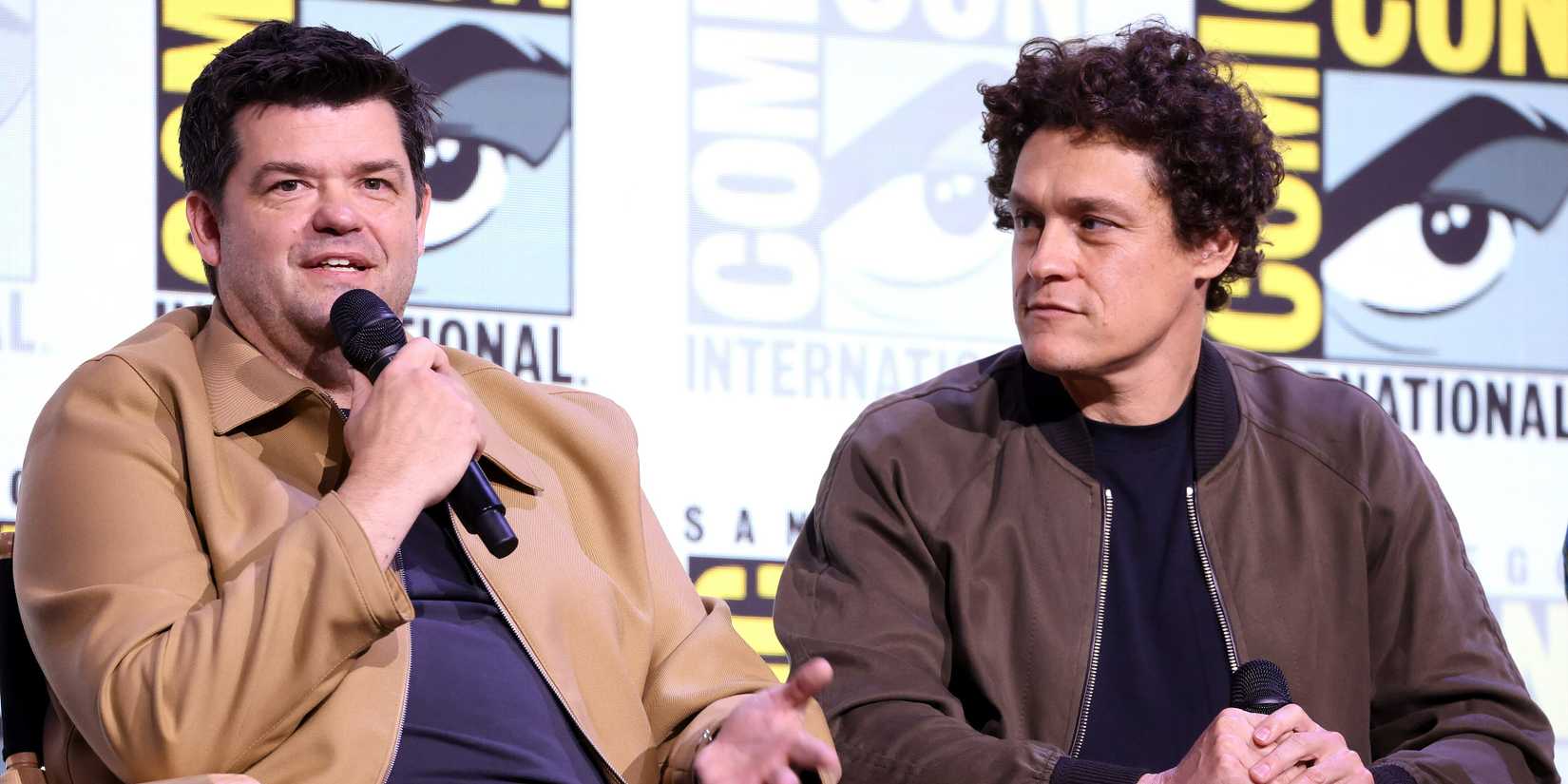 Christopher Miller speaking into a microphone next to Phil Lord at San Diego Comic Con in 2025 