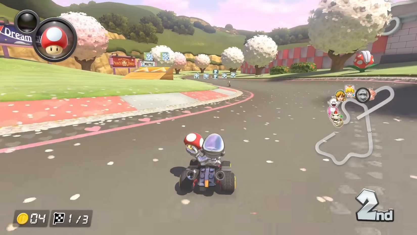Tangkapan layar Mario Kart 8 Deluxe menunjukkan Metal Mario berlomba di lapangan N64 Royal Raceway