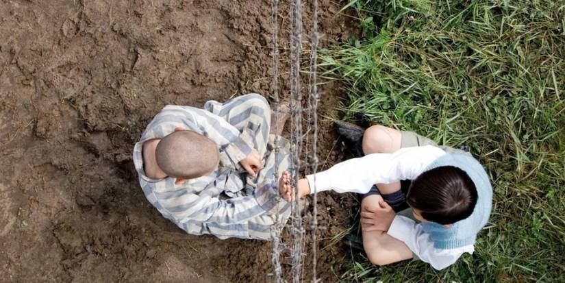 Bruno and Shmuel touch palms across barbed wire in The Boy in the Striped Pyjamas