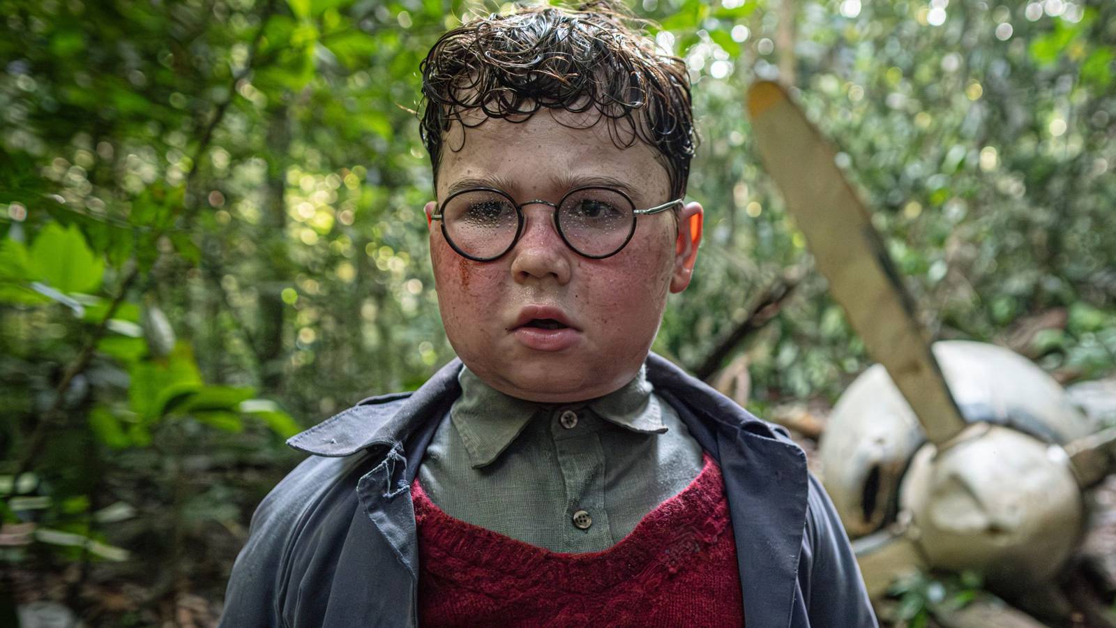 David McKenna as Ralphie stands outside a crashed plane from Netflix's Lord of the Flies