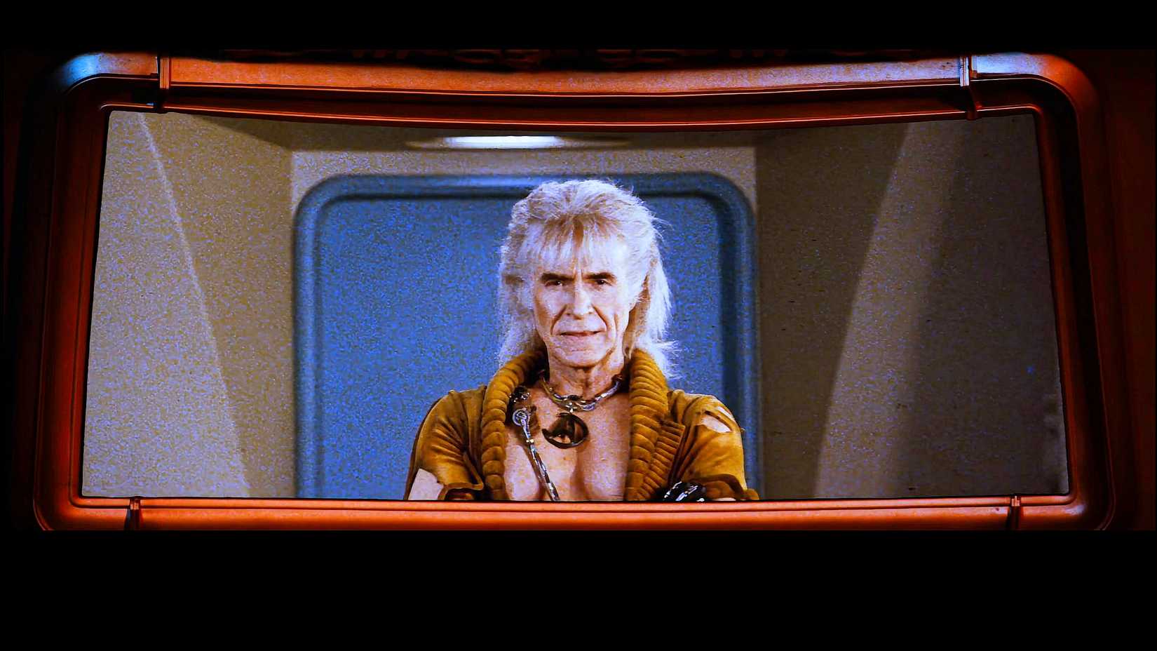 Khan Noonien Singh, arms crossed, in front of a blue door on the USS Enterprise viewscreen from Star Trek II The Wrath of Khan