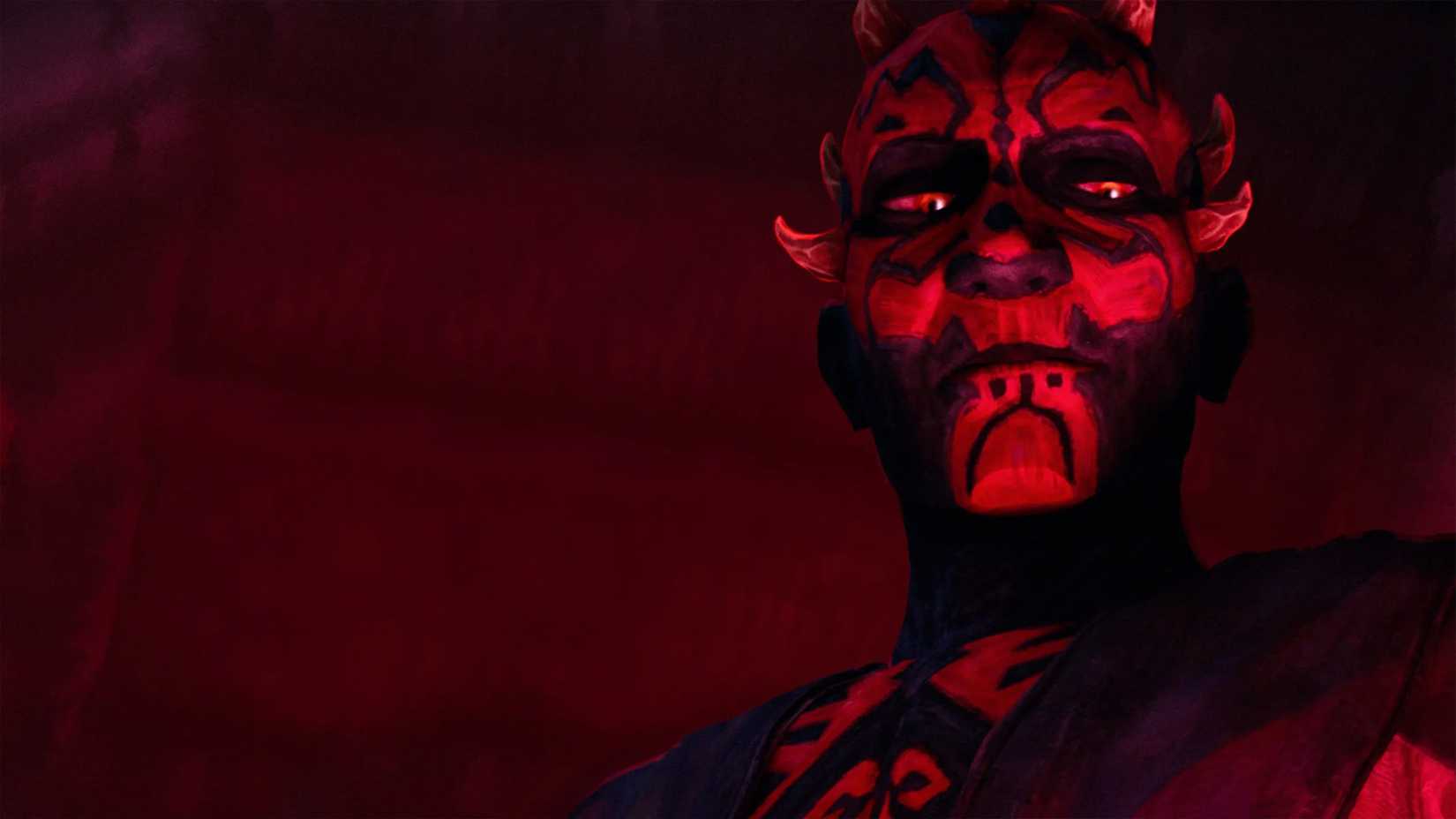Maul looks down as his face is made even more red by the glow of a red light.