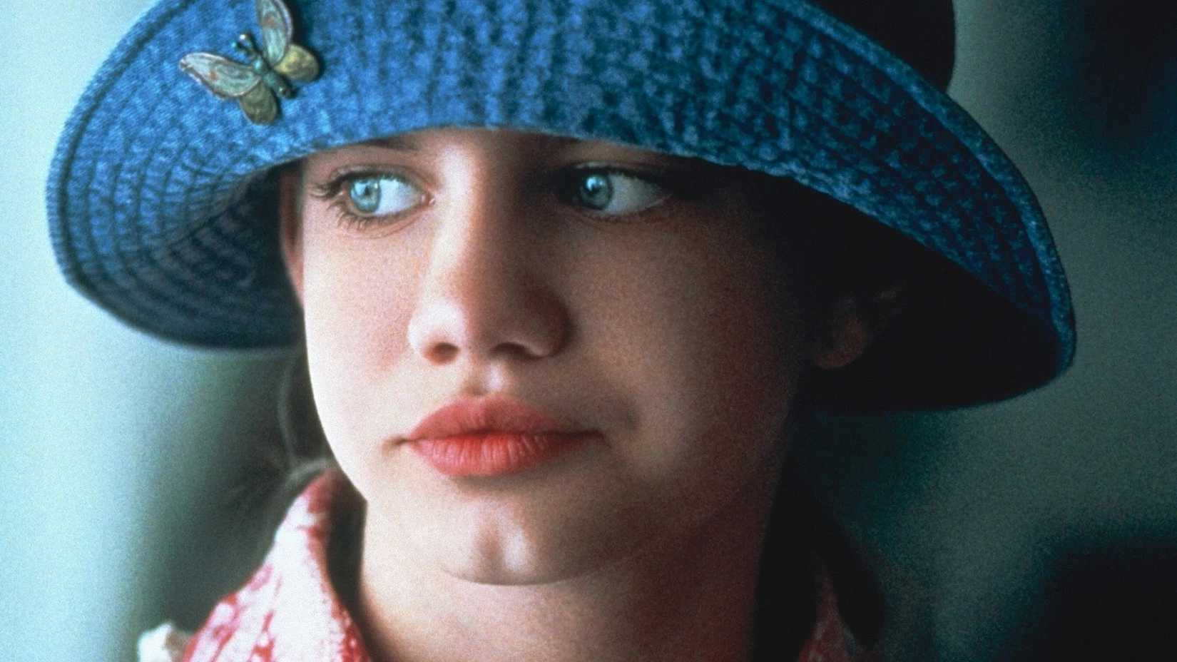 Vada looks to the side with a blue bucket hat on.
