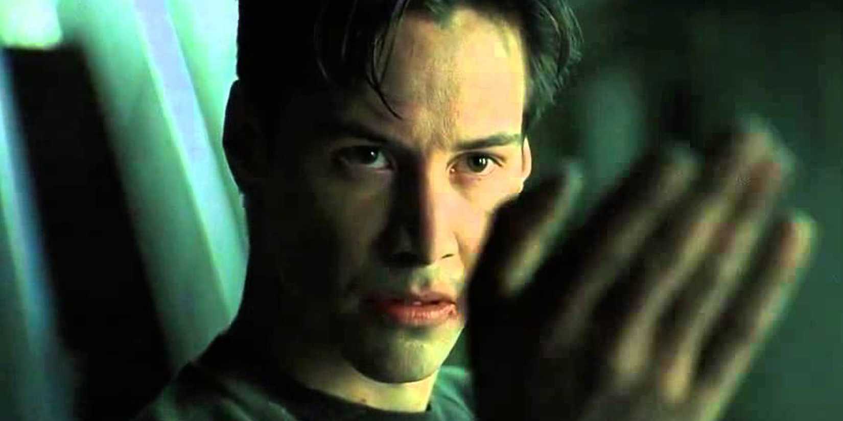 Neo with his hand out in The Matrix
