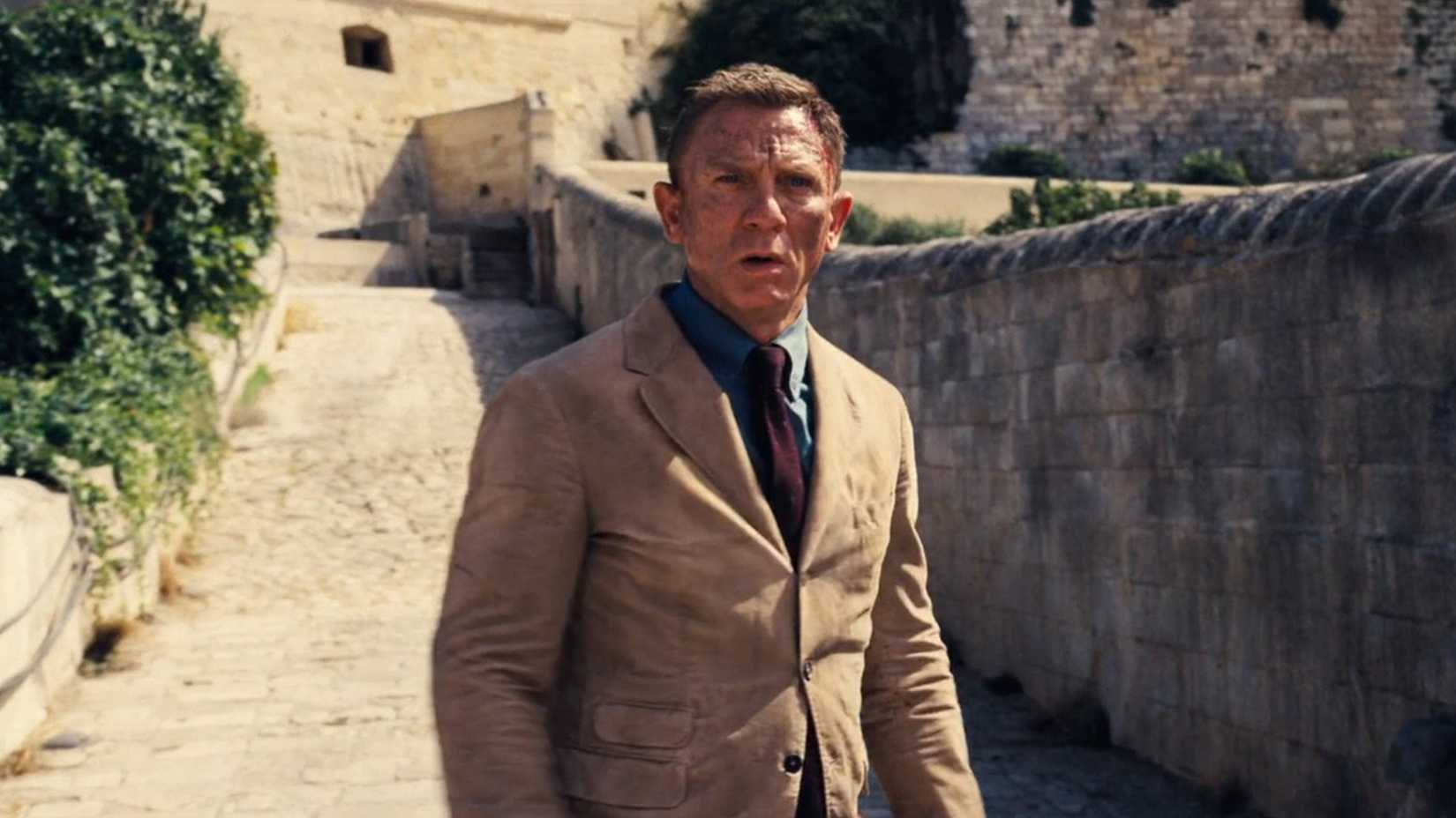 James Bond looks worse for wear in a tan suit.