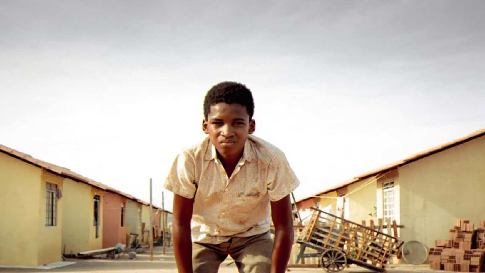 An adolescent boy looks at the camera in the 2002 movie City of God