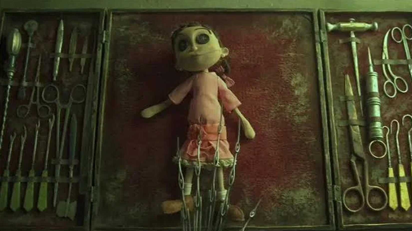 A doll in a pink dress with button eyes is about to be dissected on a table near metal tools in Coraline.