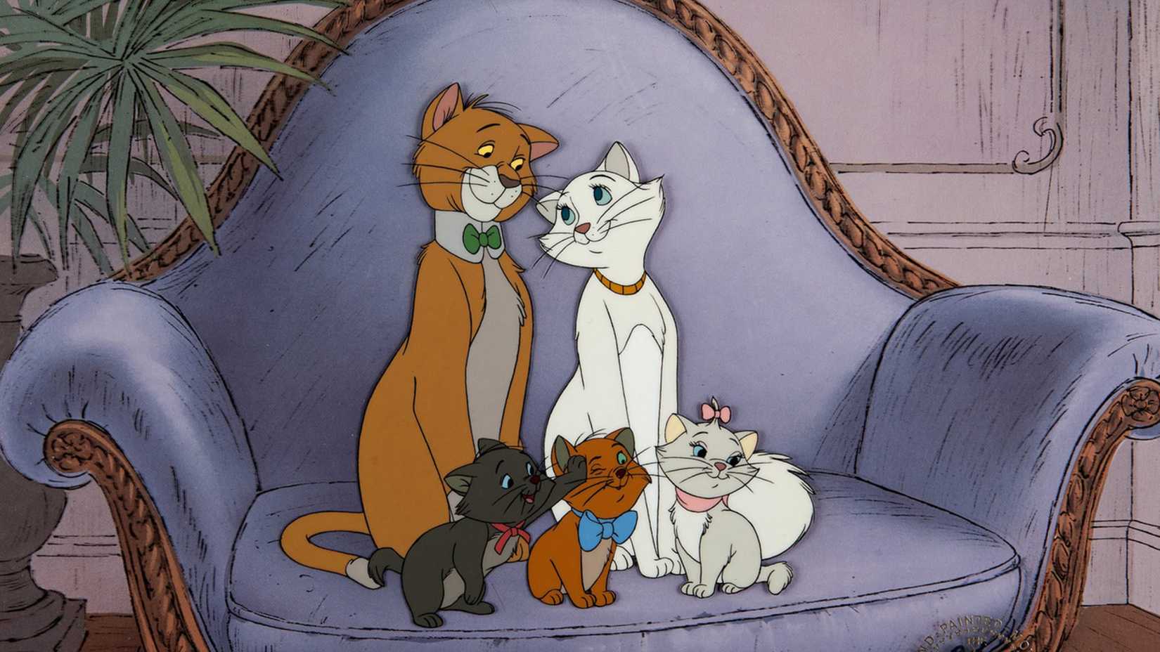 The family of aristocats sit on a chair.