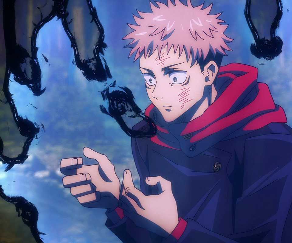 Yuji Itadori looks down at his hands as cursed energy flares up around him in Jujutsu Kaisen.