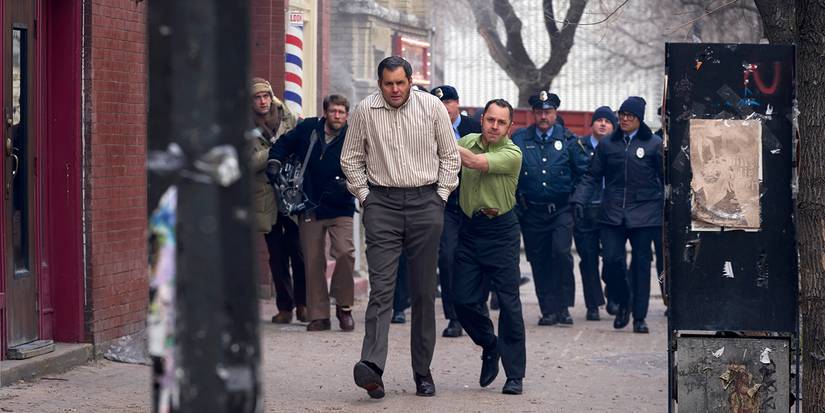 Tony walking Dick through the streets with a gun to this head as police follow in American Hostage.