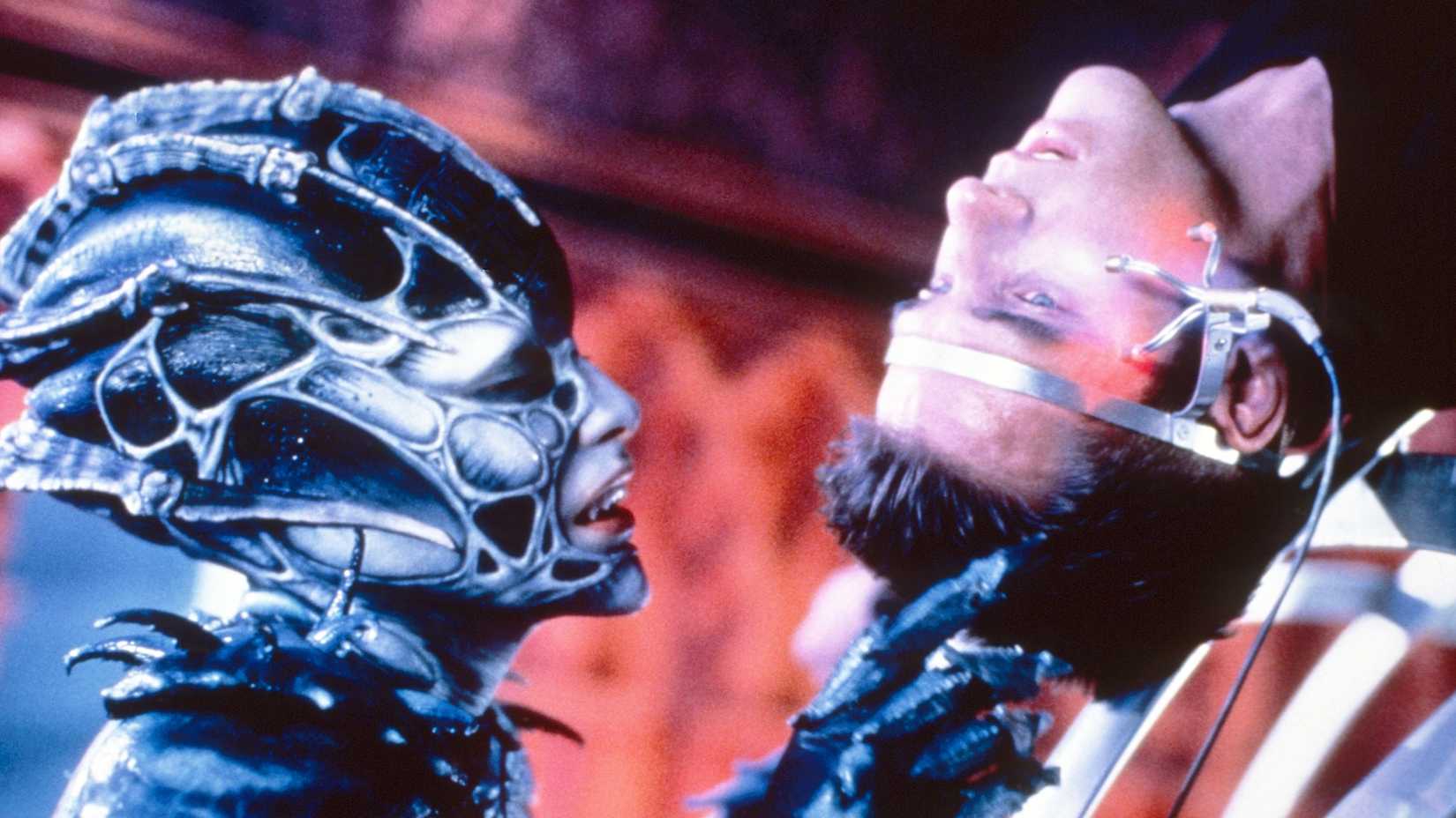 An alien studies Ben Browder in Farscape