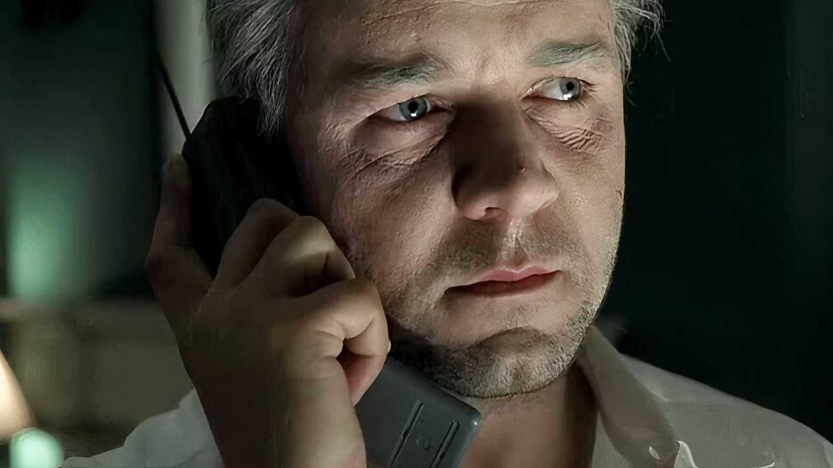 Russell Crowe looks old and holds a phone in The Insider.