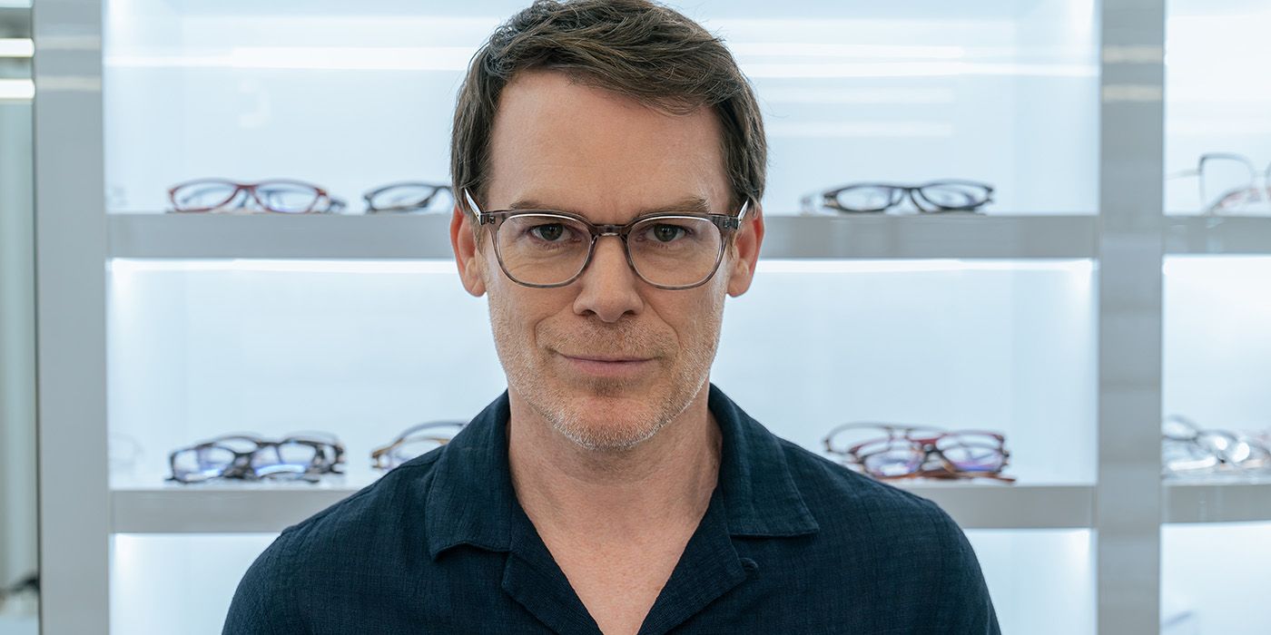 Dexter staring ahead waring glasses with rows of glasses in a store behind him in Dexter: Resurrection.