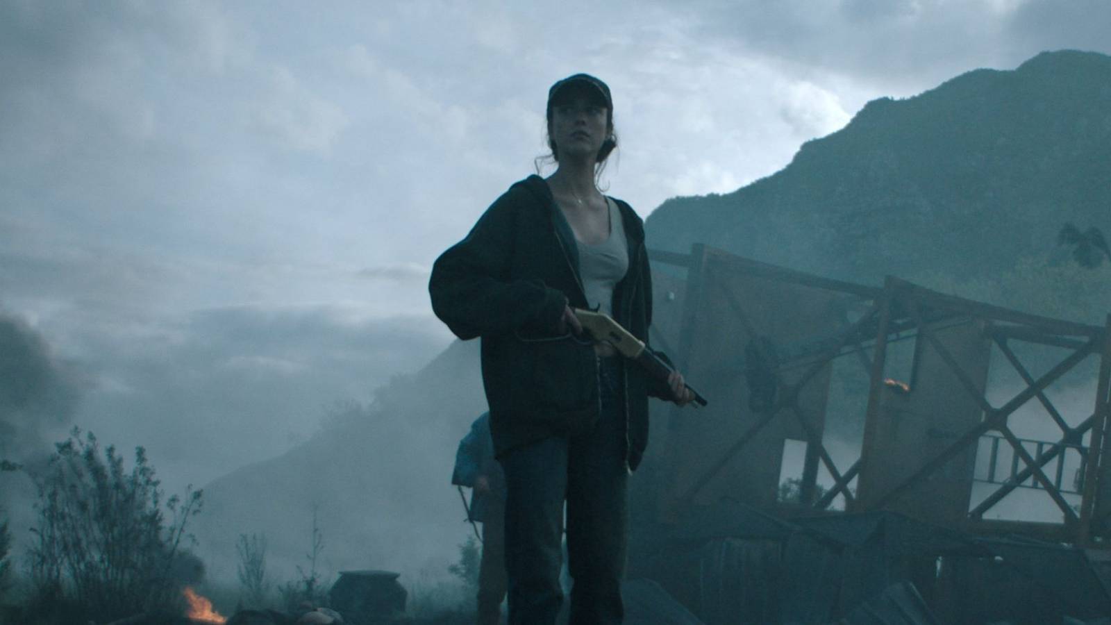 Margaret Qualley holding a weapon in the fog of an explosion in Ridley Scott's sci-fi The Dog Stars
