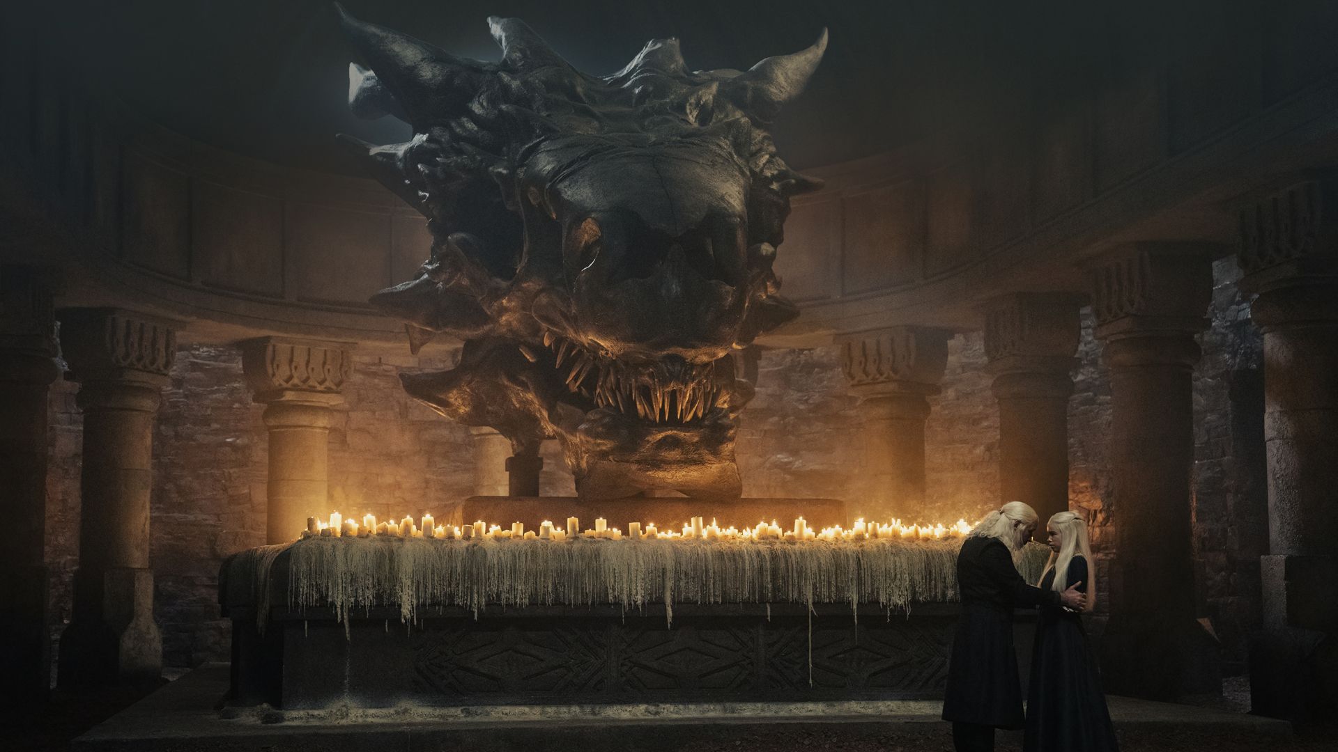 Viserys and Rhaenyra talk in fron of the massive skull of a dragon in House of the Dragon