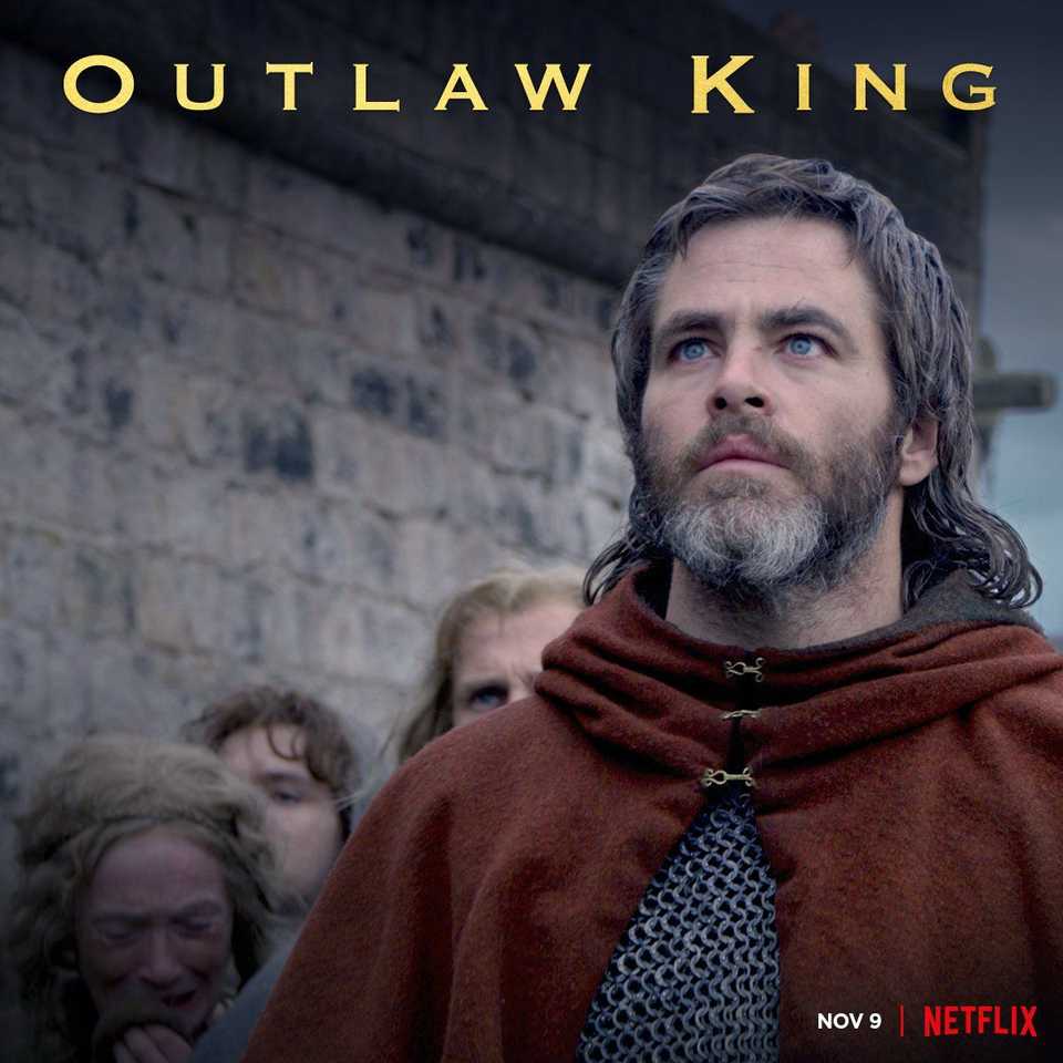 Bruce the King (Chris Pine) mira hacia arriba mientras otros a su alrededor parecen preocupados en el cartel de Outlaw King.